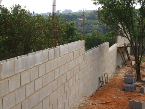 Construção de muro de divisa em blocos de concreto com ferragens verticais, executado por pedreiro profissional em Jaraguá do Sul