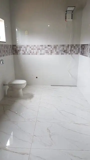Porcelanato e revestimentos em Jaraguá do Sul — Pedreiro JC Pedreiro azulejista em Jaraguá do Sul instalando porcelanato de grande formato com nivelamento perfeito — colocação de piso e revestimentos cerâmicos pelo Pedreiro JC (João Carlos).